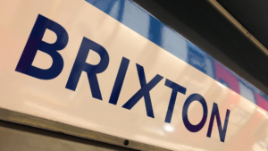 Immagine puramente decorativa dell'articolo "Brixton, quartiere di Londra multietnico e colorato". In questa foto viene mostrato il cartellone della Tube di Londra indicante la fermata "Brixton".