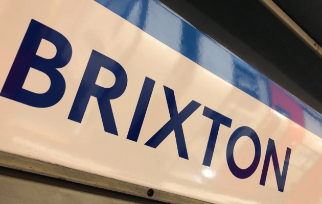 Immagine puramente decorativa dell'articolo "Brixton, quartiere di Londra multietnico e colorato". In questa foto viene mostrato il cartellone della Tube di Londra indicante la fermata "Brixton".
